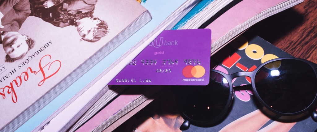 Cartão de crédito Nubank em meio a livros e revistas