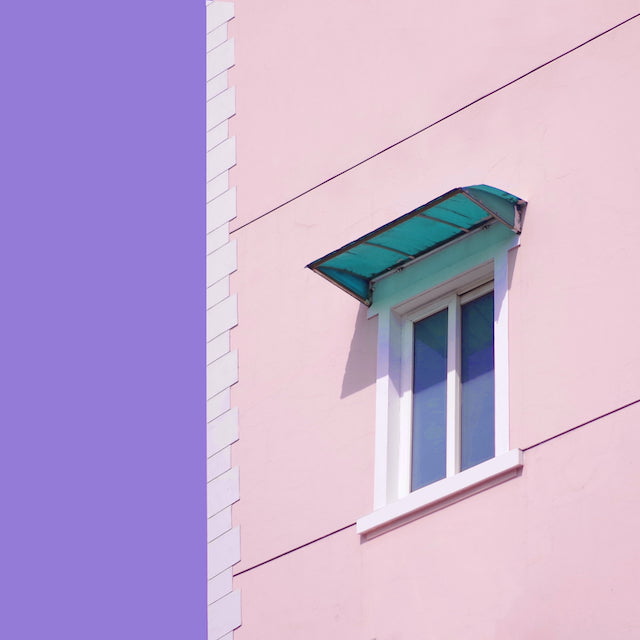 IPTU 2024: imagem da janela de uma casa. A janela é branca e a parede da casa é rosa.