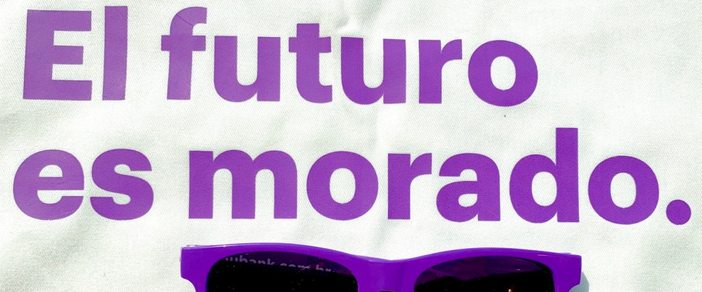 Letras roxas em fundo branco escrito El Futuro es Morado - ou o futuro é roxo, em espanhol, ao lado de um óculos escuro roxo