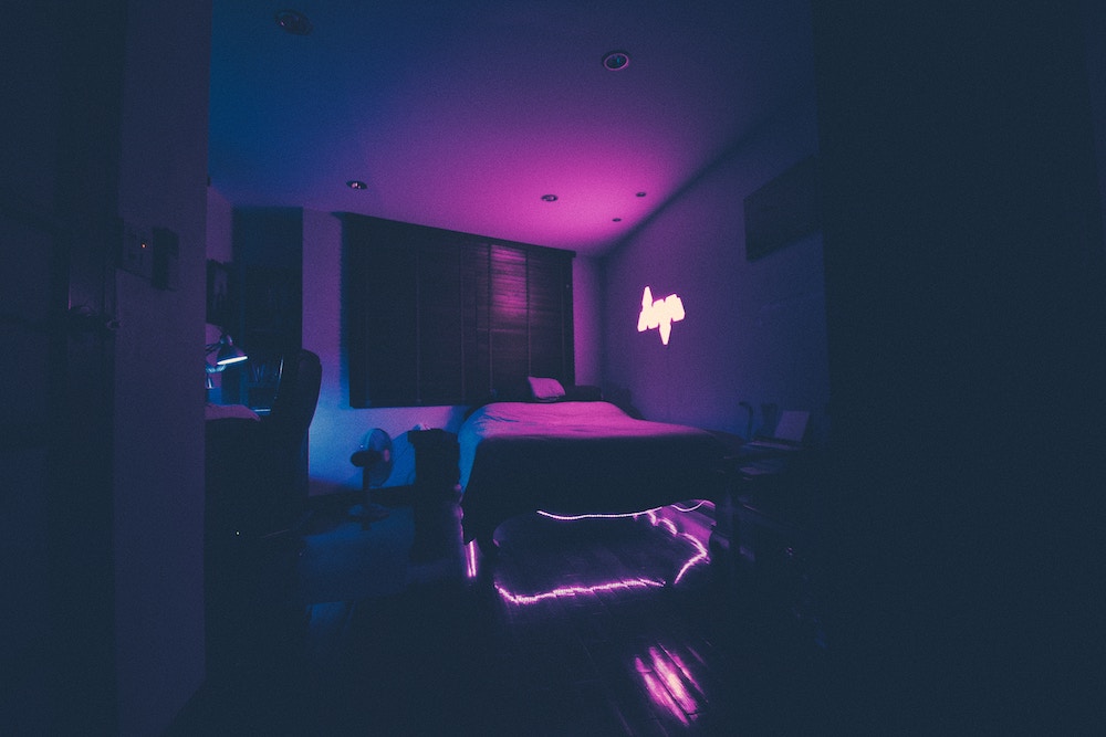 Foto de um quarto iluminado por uma luz roxa.