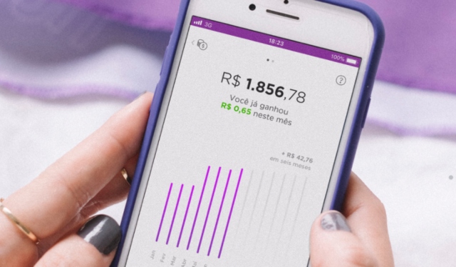 Mão segurando celular com o aplicativo Nubank aberto na área da NuConta