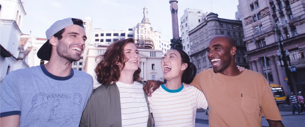 Como sacar dinheiro na NuConta: grupo de 4 amigos andando abraçados e sorrindo