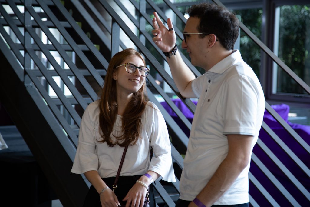 Dois estudantes conversando ao pé da escada no escritório do Nubank.