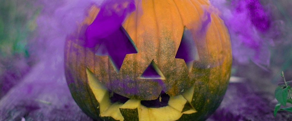 Halloween: uma abóbora de halloween com uma fumaça roxa saindo de dentro.