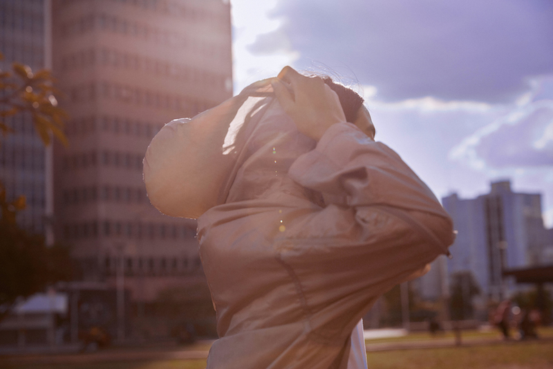 Metodologia ágil: mulher no parque colocando o capuz de um casaco
