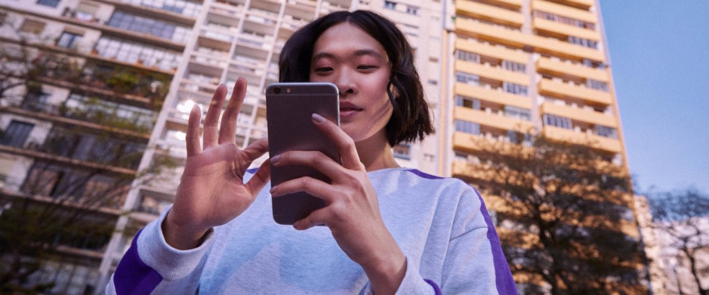 NuConta: foto mostra mãos em primeiro plano segurando um telefone