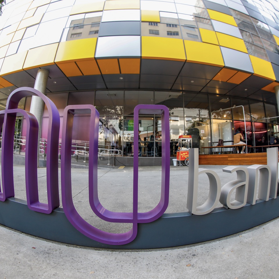 Foto com câmera olho de peixe feita na fachada do Nubank mostra o logo da empresa com efeito aumentado