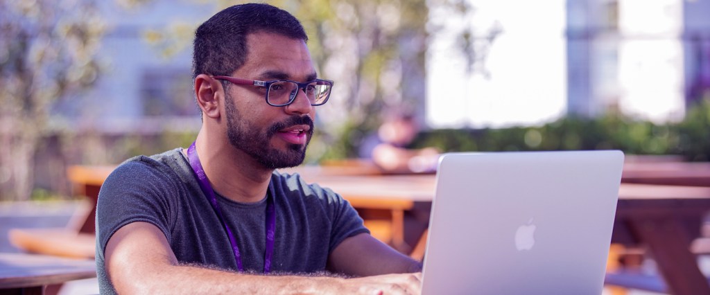 Nubank trabalhando de casa: foto de um homem sentado em uma varanda, digitando em um notebook