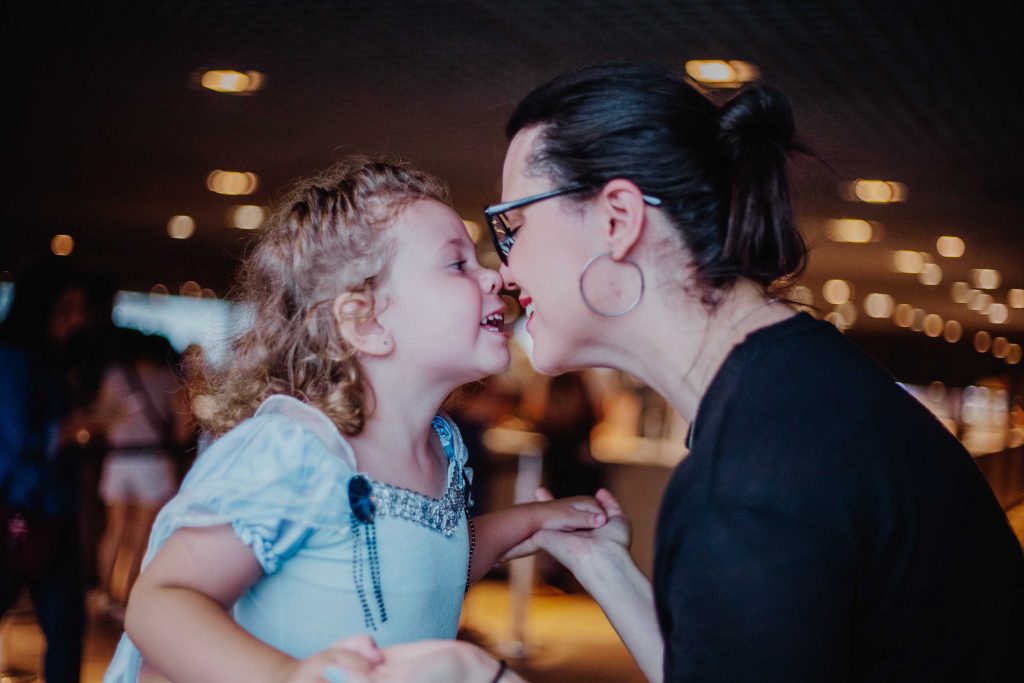 Damaris encostando o nariz no nariz de sua filha, Rebecca. Ambas sorrindo.