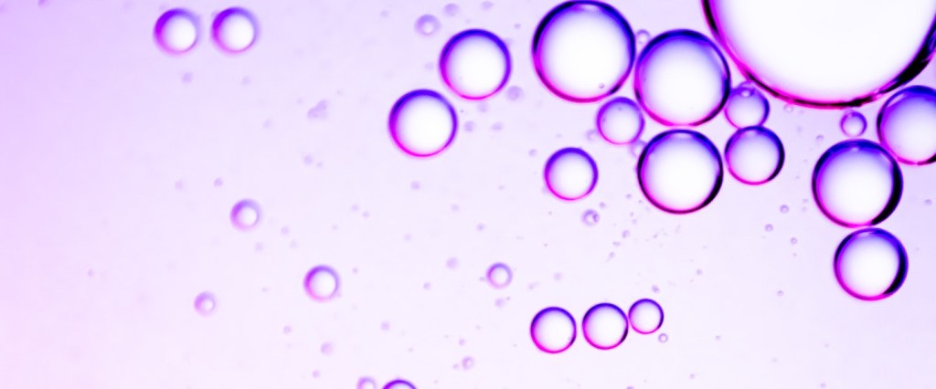 imagem de bolhas roxas de vários tamanhos em um fundo rosa claro
