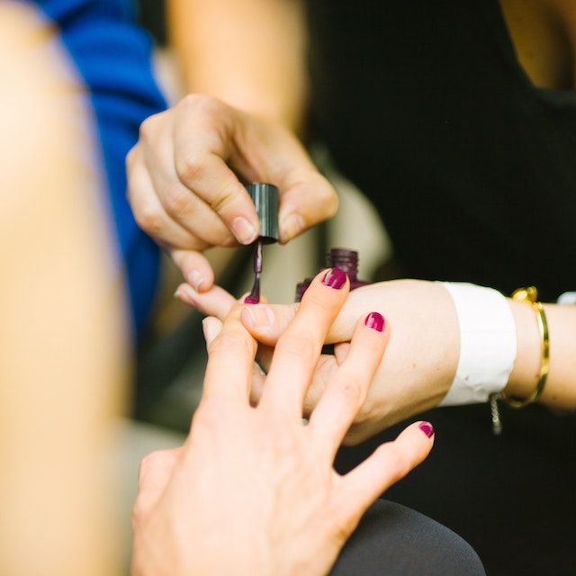 5 dúvidas sobre MEI: fotografia em close de uma manicure pintando a unha de uma cliente de vermelho