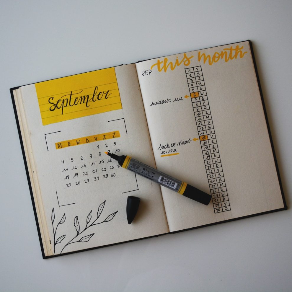 Uma agenda com um calendário desenhado com canetas preta e amarela