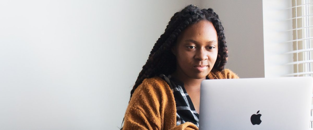 Começar um negócio: fotografia de uma mulher mexendo no notebook apoiado na mesa