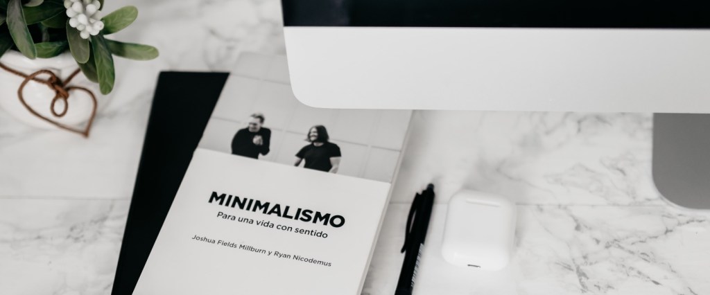 imagem minimalista, preta e branca, com imagem do livro em cuja capa está escrito minimalismo, caneta e partes de um computador