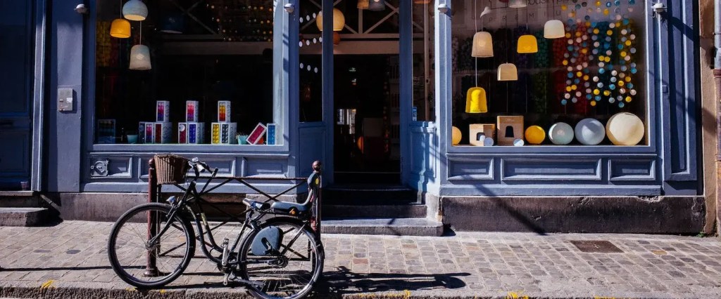 Capital social: fotografia da fachada de uma loja com vitrine de vidro e uma bicicleta parada em frente.