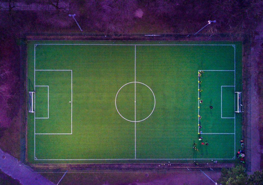 imagem de um campo de futebol com os arredores em tons de roxo