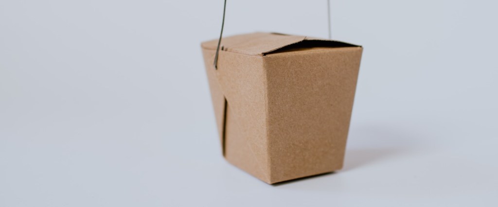 Pandemia faz número de MEIs aumentar: fotografia de uma caixinha de comida de papel pardo num fundo branco
