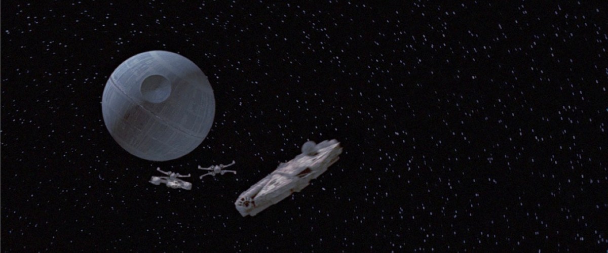 Foto do filme Star Wars mostra o espaço com a estação Estrela da orte, redonda, e duas naves perseguindo a Millenium Falcon. Credito da foto: Divulgação StarWars.com