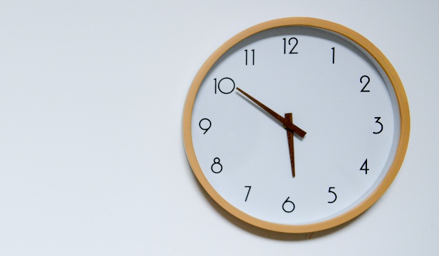 auxílio emergencial aniversariantes outubro: foto de relógio com moldura de madeira e fundo branco. Foto: Unsplash @Cast Coming