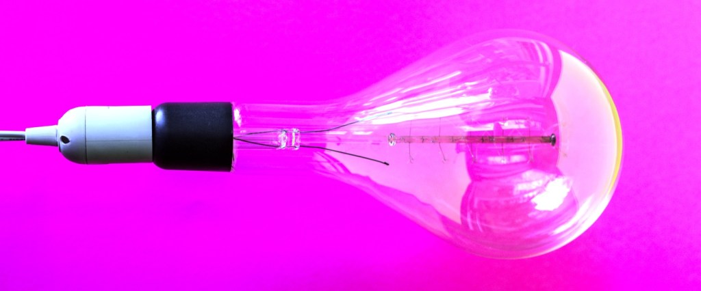 conta de luz vai subir: imagem de uma lâmpada com fundo roxo. Unsplash/Nathan Dumlao