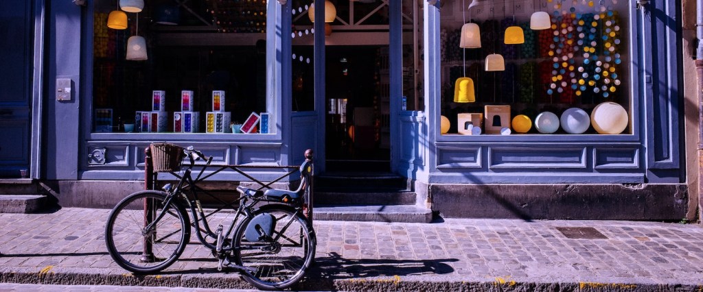 Microempresa: fotografia da fachada de uma loja roxa com grandes vitrines. Em frente à loja tem uma bicicleta apoiada em uma grade.