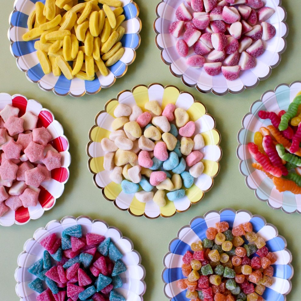 FoF: Vista de cima de uma mesa com vários pratinhos coloridos, cada um repleto de doces diferentes. Foto: Analia Baggiano.