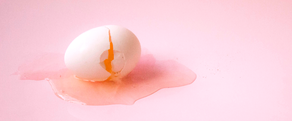 processo seletivo: ovo quebrado com fundo rosa. Foto: @bailedelanguis/ Unsplash