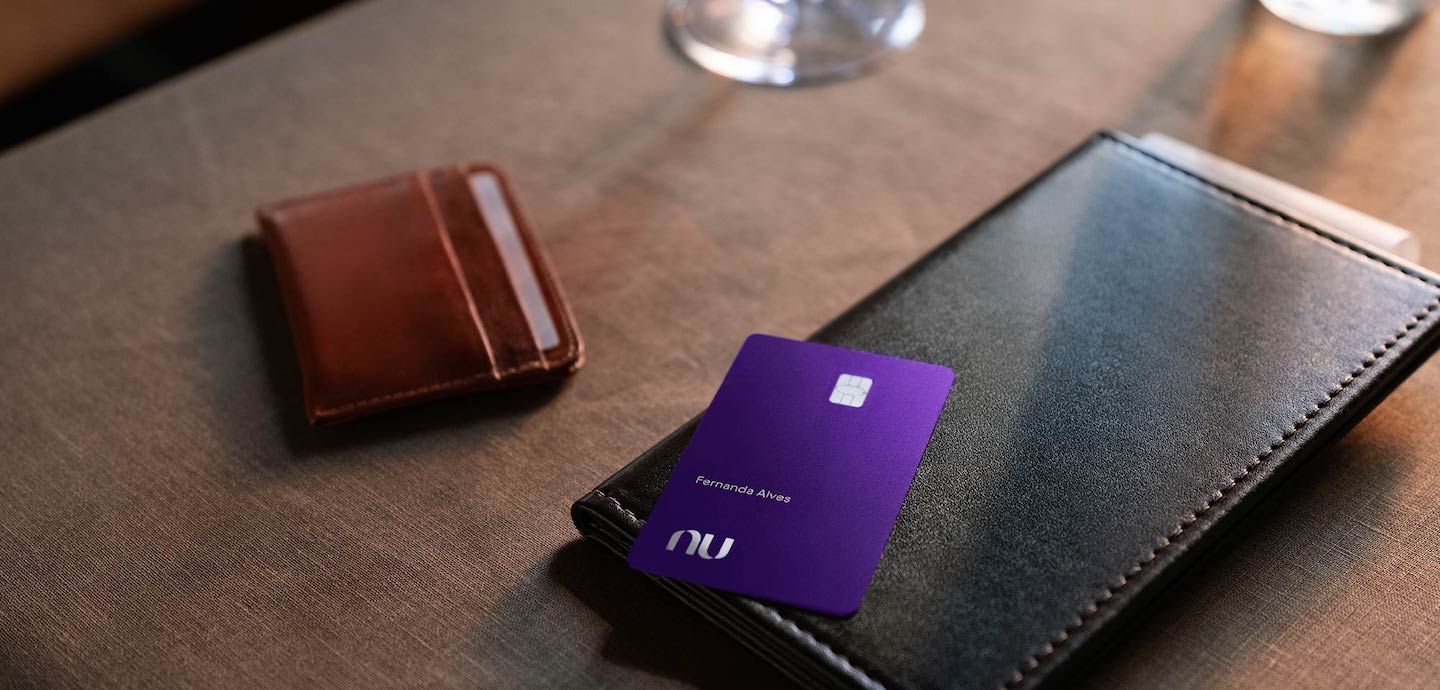 imagem do cartão Ultravioleta em cima de uma mesa, ao lado de uma carteira.