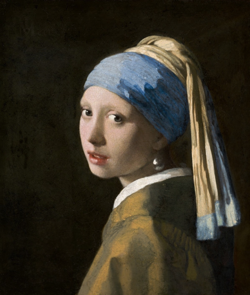 Reprodução da pintura de Vermeer em que aparece uma moça jovem olhando de perfil em direção ao observador, com um pano azul e amarelo sobre a cabeça e um manto bege e um brinco de pérola na orelha