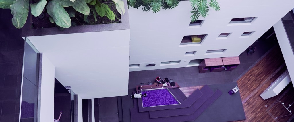 Escritório do Nubank: vista de um andar de cima olhando para baixo, onde há uma piscina de bolinhas roxas em meio a um saguão
