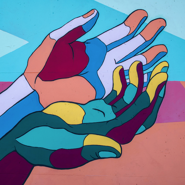 BPC. Arte pintada em um muro: mãos abertas e coloridas a partir de figuras geométricas. Créditos: Tim Mossholder, Unsplash