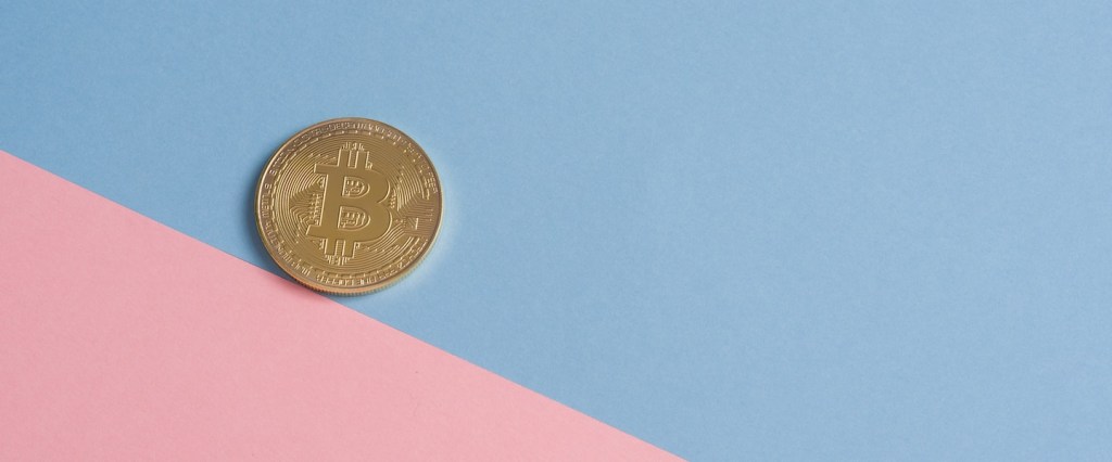 El Salvador adota bitcoin moeda oficial: uma moeda dourada de bitcoin sobre uma superfície azul e rosa. Créditos da imagem: Icons8 Team