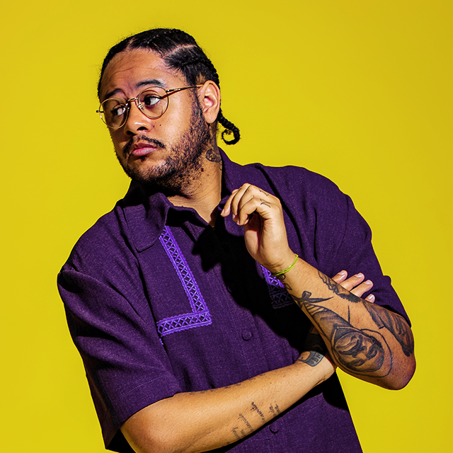 Emicida: imagem do rapper com uma camisa roxa e fundo amarelo. Foto: Laboratório Fantasma