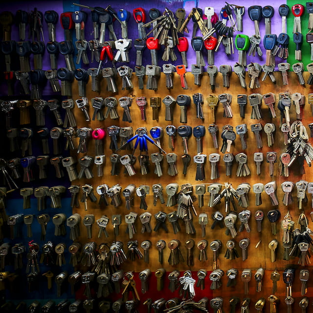 Vai compartilhar as suas chaves Pix? Cuidado. Diferentes tipos de chaves penduradas em uma parede colorida, lado a lado. Créditos: Chuncli, unsplash.