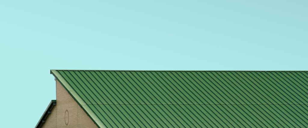 Como financiar um imóvel: fotografia do telhado verde de uma casa com o céu azul ao fundo. Créditos da imagem: Simone Hutsch