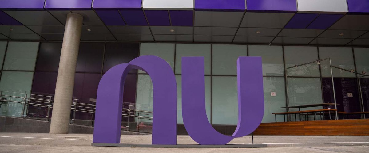 Imagem da fachada do prédio do Nubank em São Paulo, com o logo NU roxo em evidência