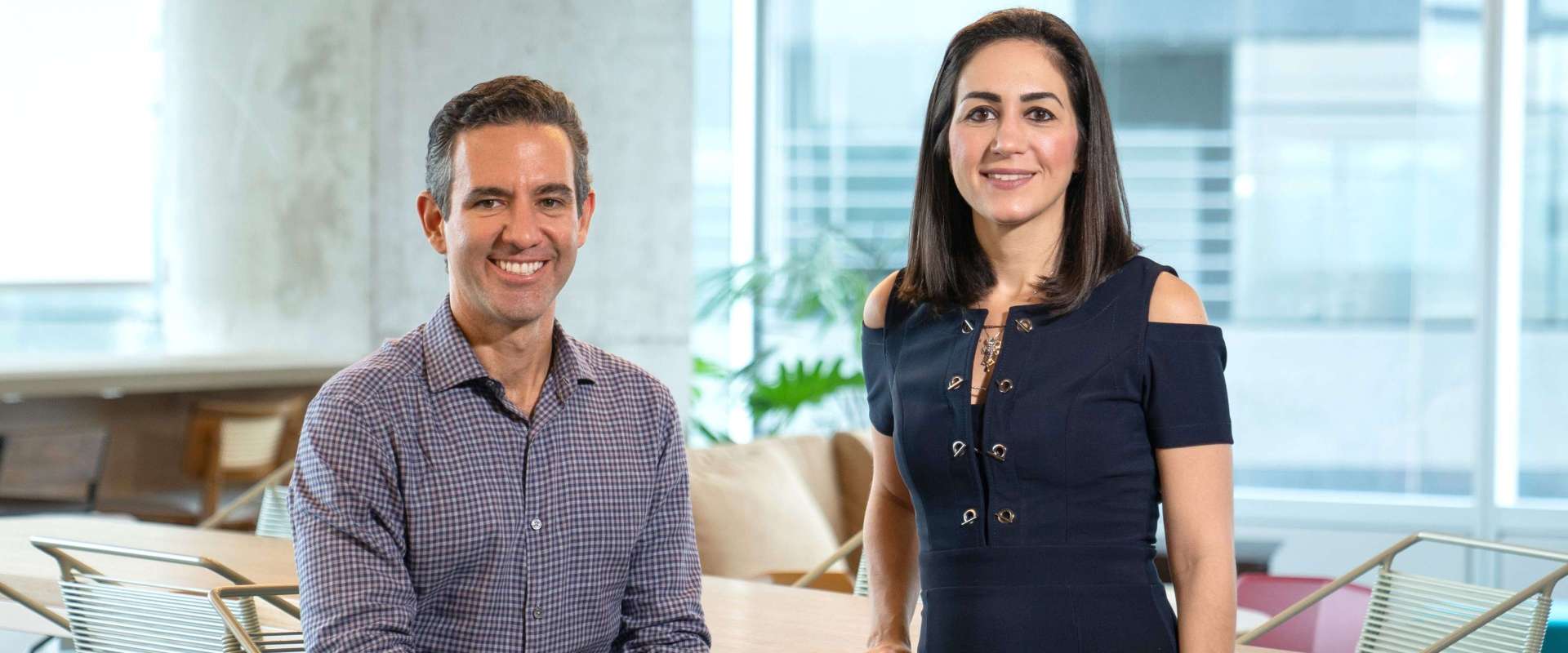 Na imagem aparecem, ao centro, os fundadores do Nubank. À esquerda, David Vélez, um homem branco de cabelos curtos, trajando uma camisa de botão xadrez azulada. À direita, Cristina Junqueira, uma mulher branca, de cabelos castanhos na altura dos ombros, trajando um conjunto de colete e calça jeans escuro.