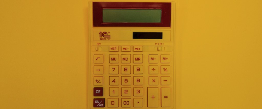 Pró-rata: o que é e como calcular? Imagem de uma calculadora amarela em fundo amarelo.