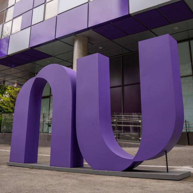 Nubank vai fechar no Brasil? Não - Na imagem, aparece a fachada do escritório do Nubank, com um grande logotipo do Nu na cor roxa colocado na calçada.