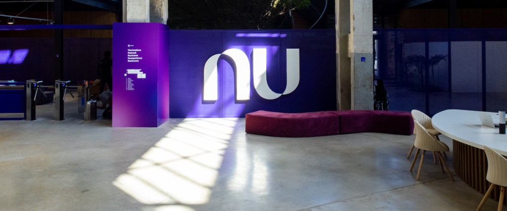 Entrada do escritório do Nubank na Vila Leopoldina, em São Paulo. Um painel roxo com o símbolo do Nu se destaca no lobby