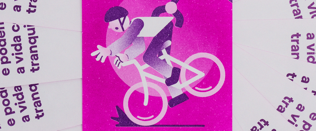 Imagem mostra um card rosa ao centro, onde aparece uma pessoa caindo de uma bicicleta.