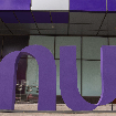 Foto da fachada do escritório do Nubank em São Paulo. Ao centro, uma peça com o logo do Nu em tamanho grande em frente à entrada.