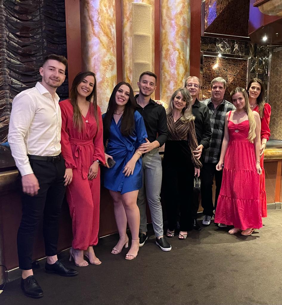 Um grupo de nove pessoas na foto, entre família e amigos de Rosana e João Francisco, em uma noite temática no navio. Todos com roupas elegantes.