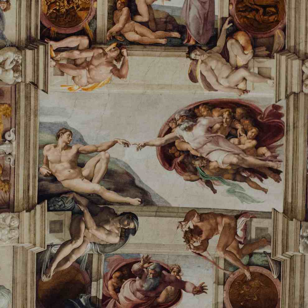 Na imagem aparece a cena clássica de Michelângelo da criação de Adão em que ele se recosta e estica o braço ficando com a ponta dos dedos quase tocando com um senhor de barba que representa Deus.