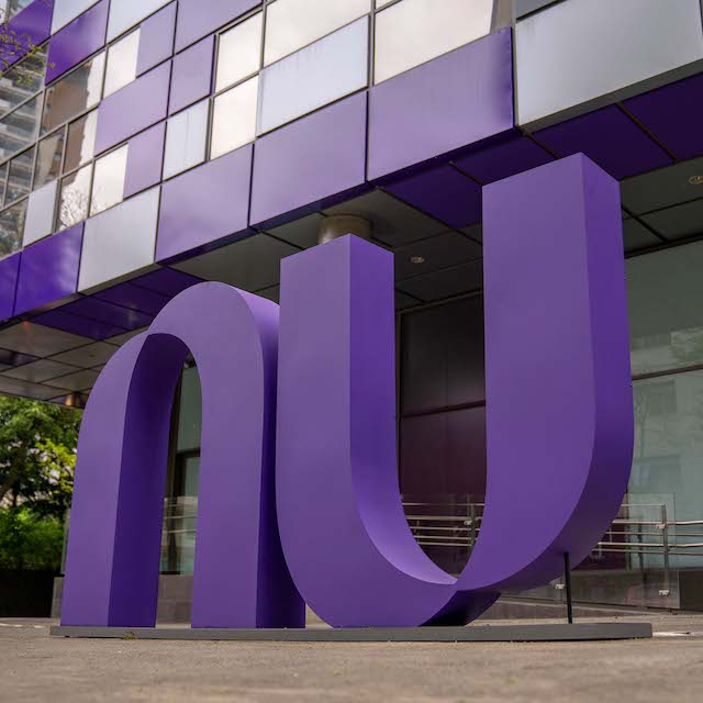 Foto mostra o logo do Nubank roxo em frente ao prédio da empresa, em São Paulo.